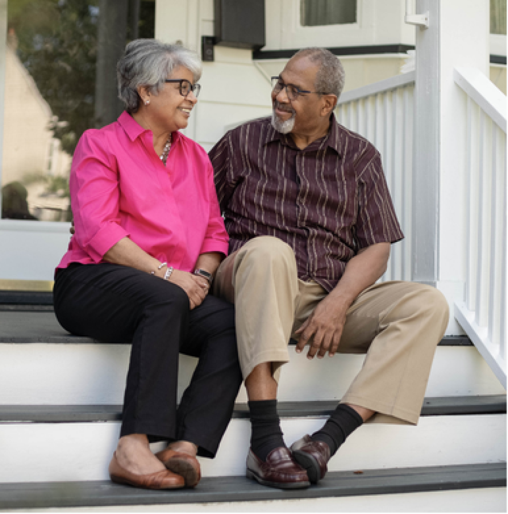 Older adult couple sitting on porch steps. 