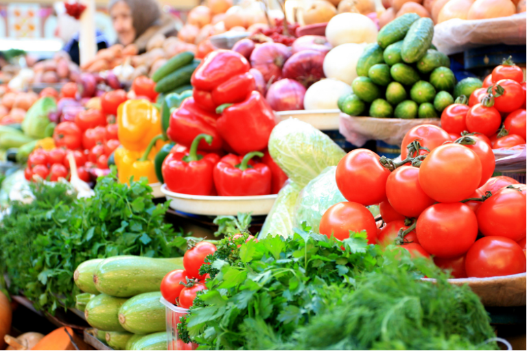 Fresh fruits, vegetables, and herbs on a farmers' market display. 